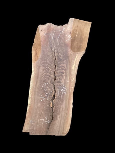 Large walnut wood slab with a crack down the center and a black background.