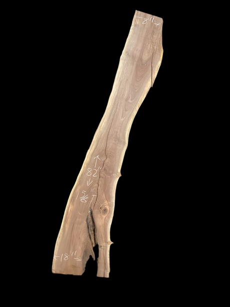A long walnut slab with a black background. 