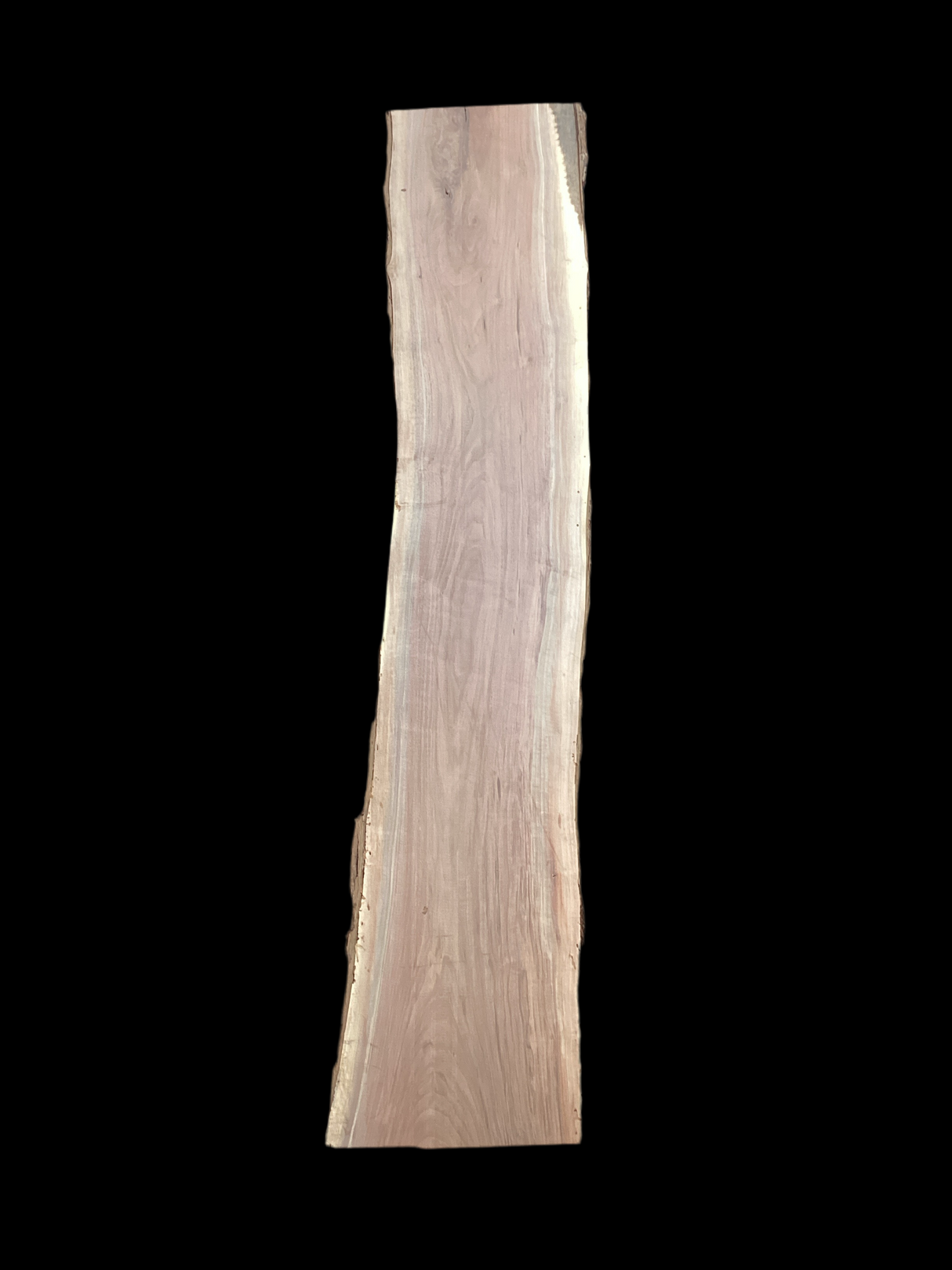 A long walnut wood slab on a black background.