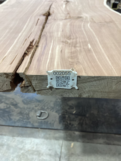 QR label attached to the edge of a walnut wood slab.