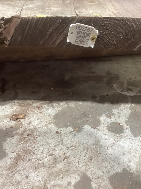 A rough, rectangular walnut wood slab with a tiger striped grain pattern, bearing a QR code with the product number '2257'.