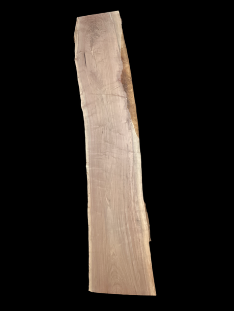 A long walnut wood slab on a black background.
