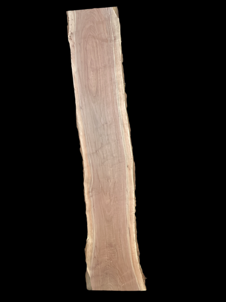 A long walnut wood slab on a black background.