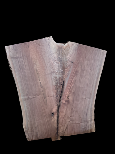 A walnut wood slab with a visible natural edge and a hole at the center, against a black background.