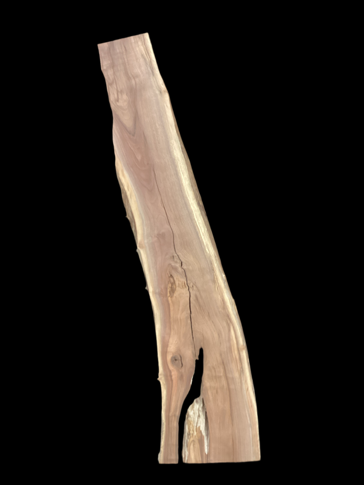 A long walnut slab with a black background. 