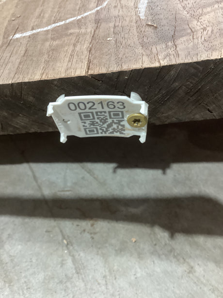 A walnut wood slab with a visible wood grain and knots, marked with a numerical code and QR code.