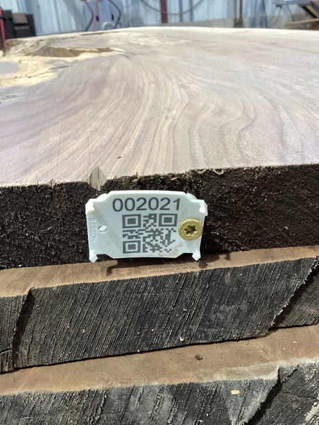 QR label attached to the edge of a walnut wood slab.