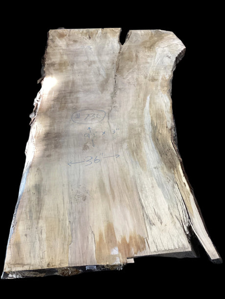 A Silver Maple wood slab with a natural, rustic appearance, featuring a beige to light brown color gradient and marked with some inscriptions.