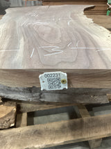 A walnut slab with visible wood grain patterns, marked with a measurement tape and a QR code tag.
