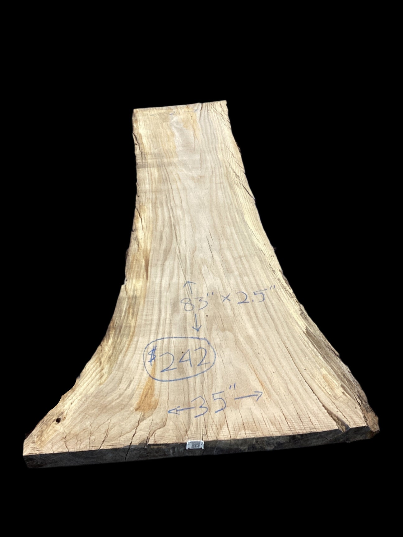 A beige-colored, solid-wood red oak slab with marked dimensions on it, indicating its size and shape.