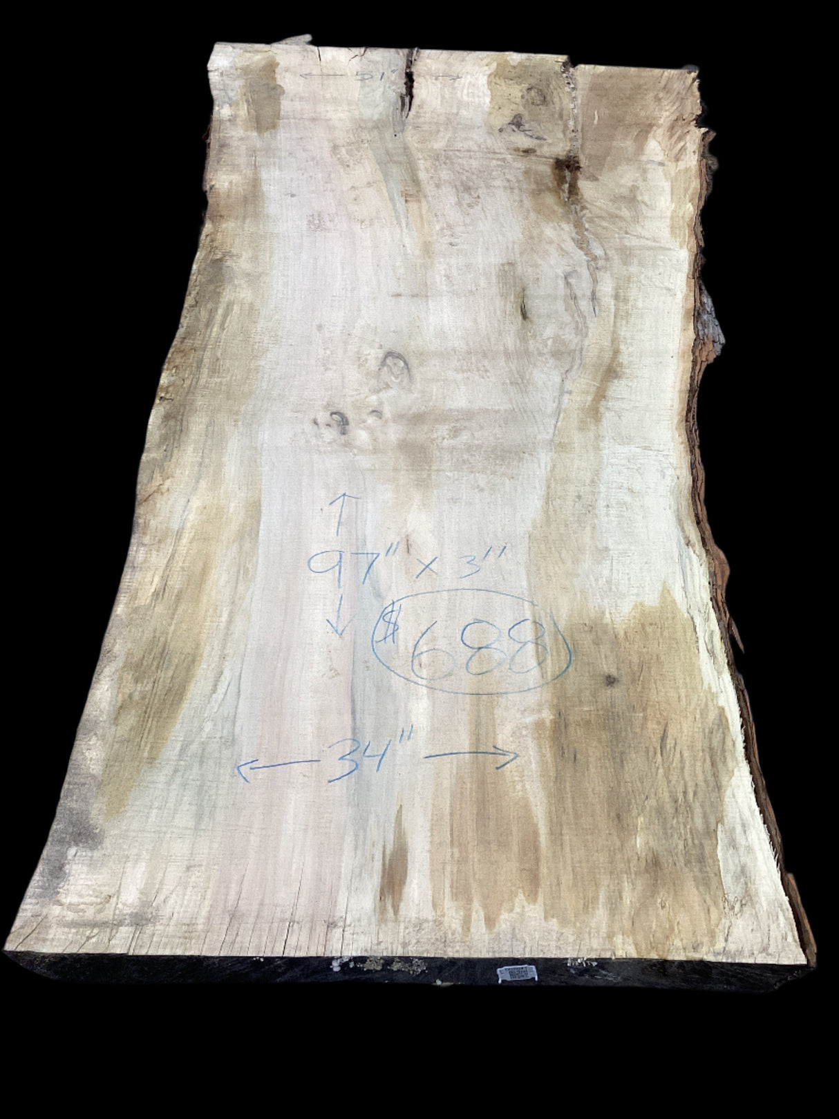 A Silver Maple wood slab with natural edges and some form of measurement or design markings on it.