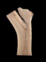 A long walnut slab with a black background. 