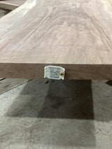 A walnut wood slab with visible natural grain patterns and a QR tag attached to it.