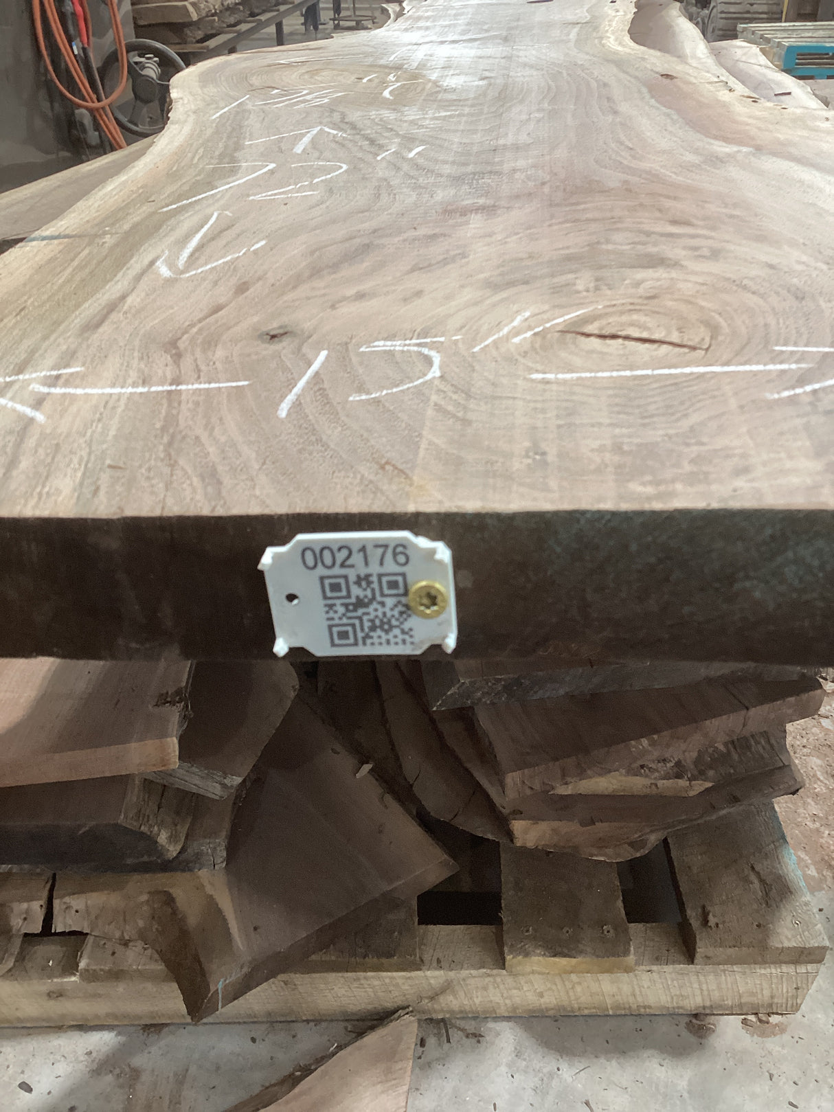 A walnut slab with visible wood grain and natural edges, marked with measurements and a QR code.