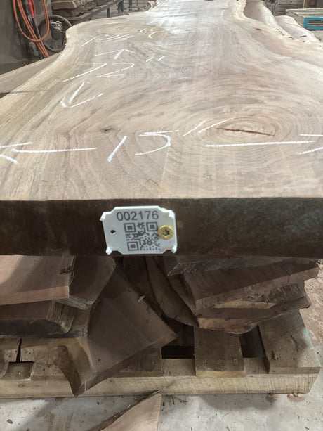 A walnut slab with visible wood grain and natural edges, marked with measurements and a QR code.