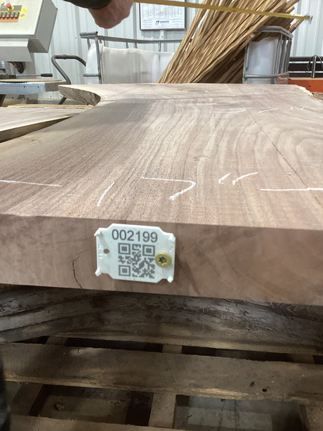 A walnut slab with a unique figure and patterns, featuring a tag with a QR code attached to the side.