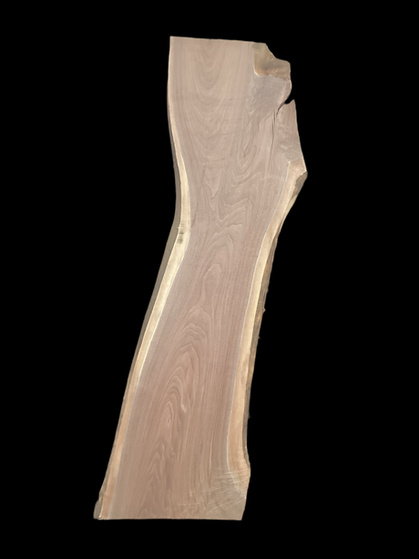 A long walnut slab on a black background. 