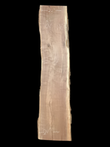 A long walnut wood slab on a black background.