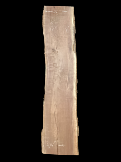 A long walnut wood slab on a black background.