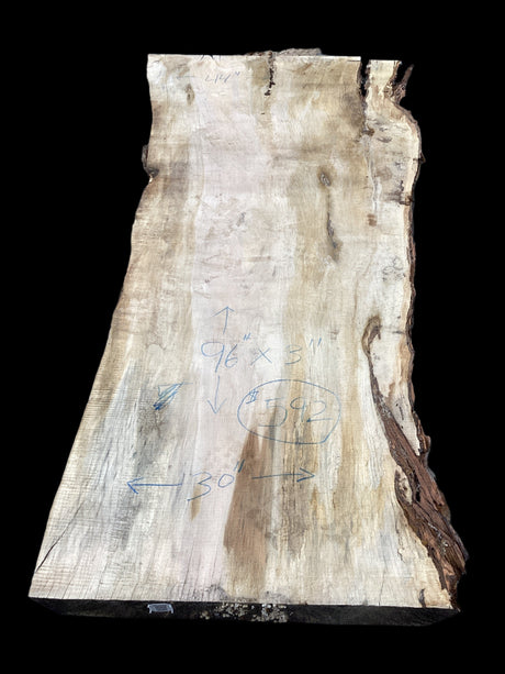 A Silver Maple wood slab with natural edges and some form of measurement or diagram on the surface.