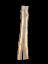 A long walnut wood slab with a split down the middle on a black background.