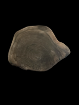 Black walnut round charcutier board on a black background.