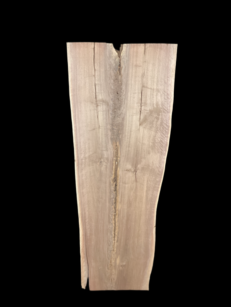 A long walnut slab, wider on one end than the other and on a black background. 