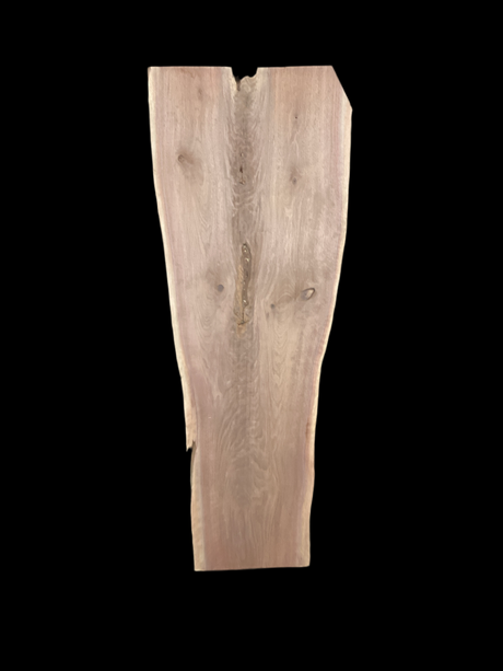 A long walnut slab, wider on one end than the other, and on a black background. 