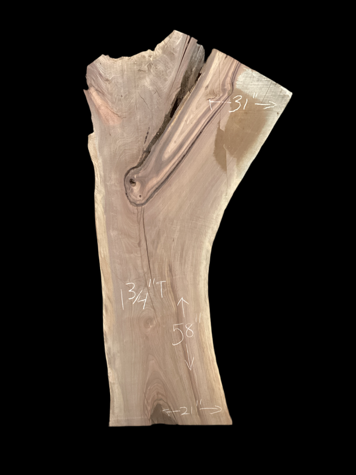 A long walnut slab with a black background. 