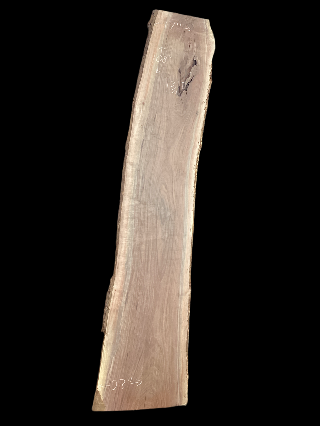 A long walnut wood slab on a black background.