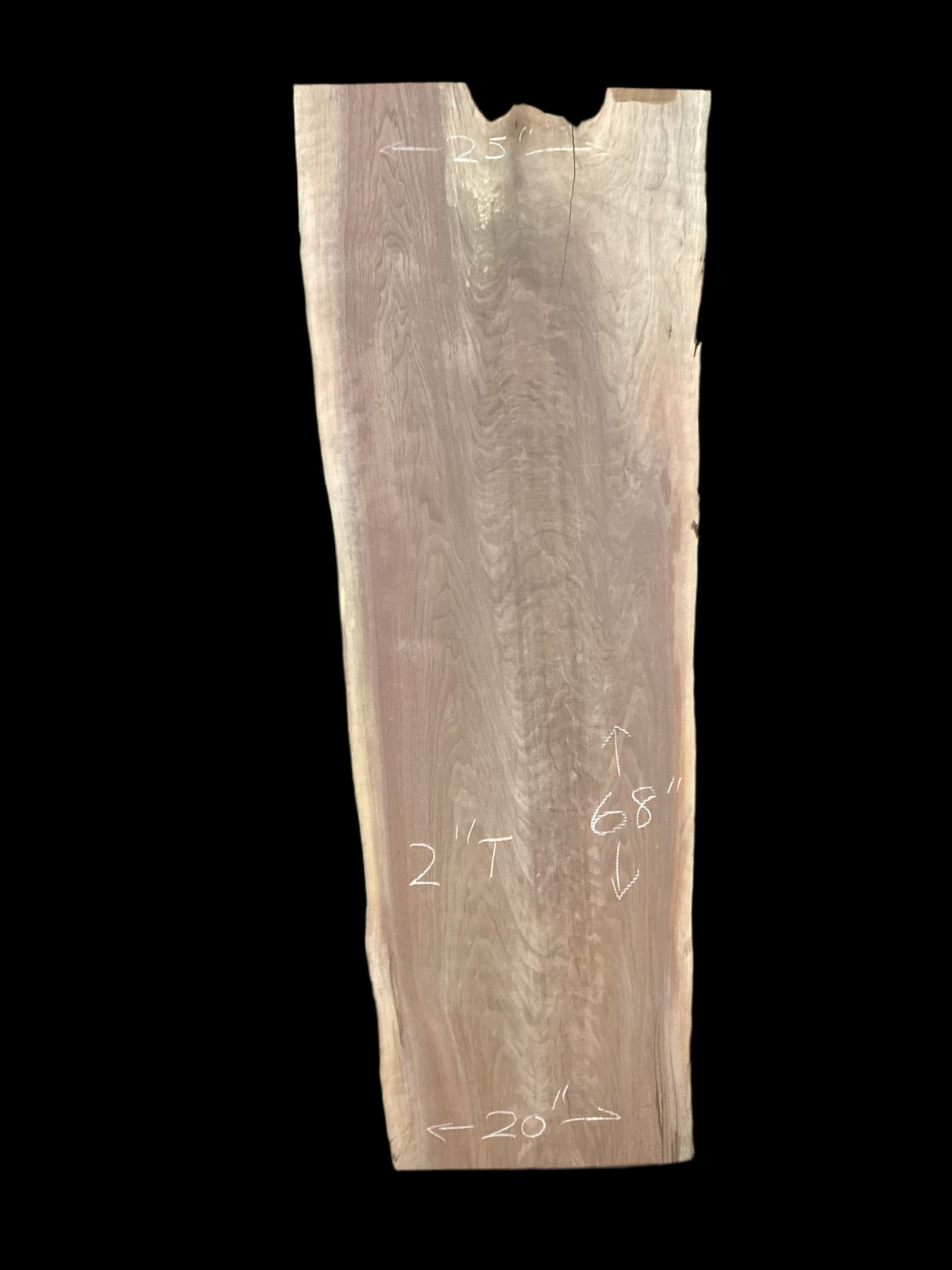A short irregular shaped walnut slab with a black background. 