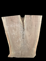 An irregularly shaped walnut slab with a distinctive striped figure pattern on a black background.