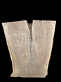 An irregularly shaped walnut slab with a distinctive striped figure pattern on a black background.