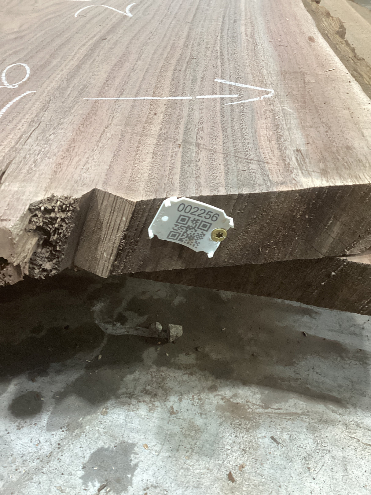 A walnut slab wood material with a visible label in the foreground, indicating the product is a bar top. The wood has a natural grain pattern.