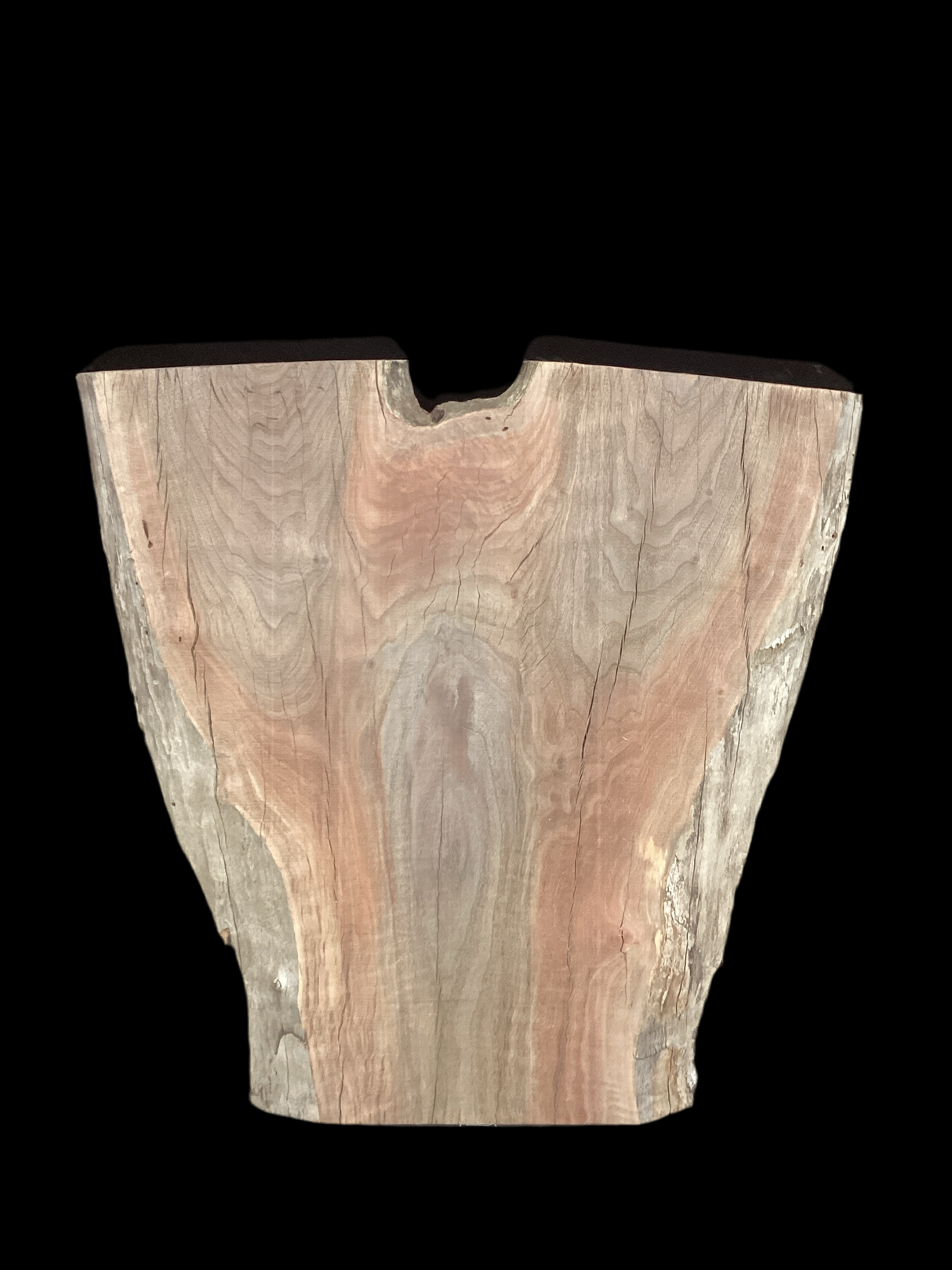 An irregularly shaped walnut slab with a distinctive striped figure pattern on a black background.