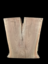 An irregularly shaped walnut slab with a distinctive striped figure pattern on a black background.