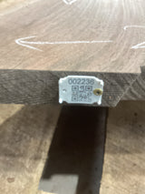 A walnut slab with a visible  QR label attached to the edge.