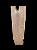 A long walnut slab, wider on one end than the other and on a black background. 