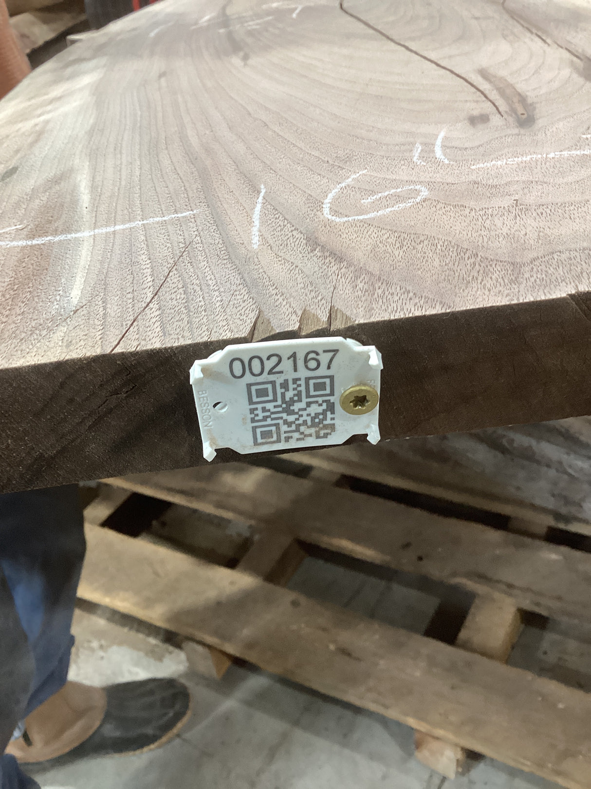 A walnut slab sofa table with a visible wood grain pattern and a QR tag attached to it.