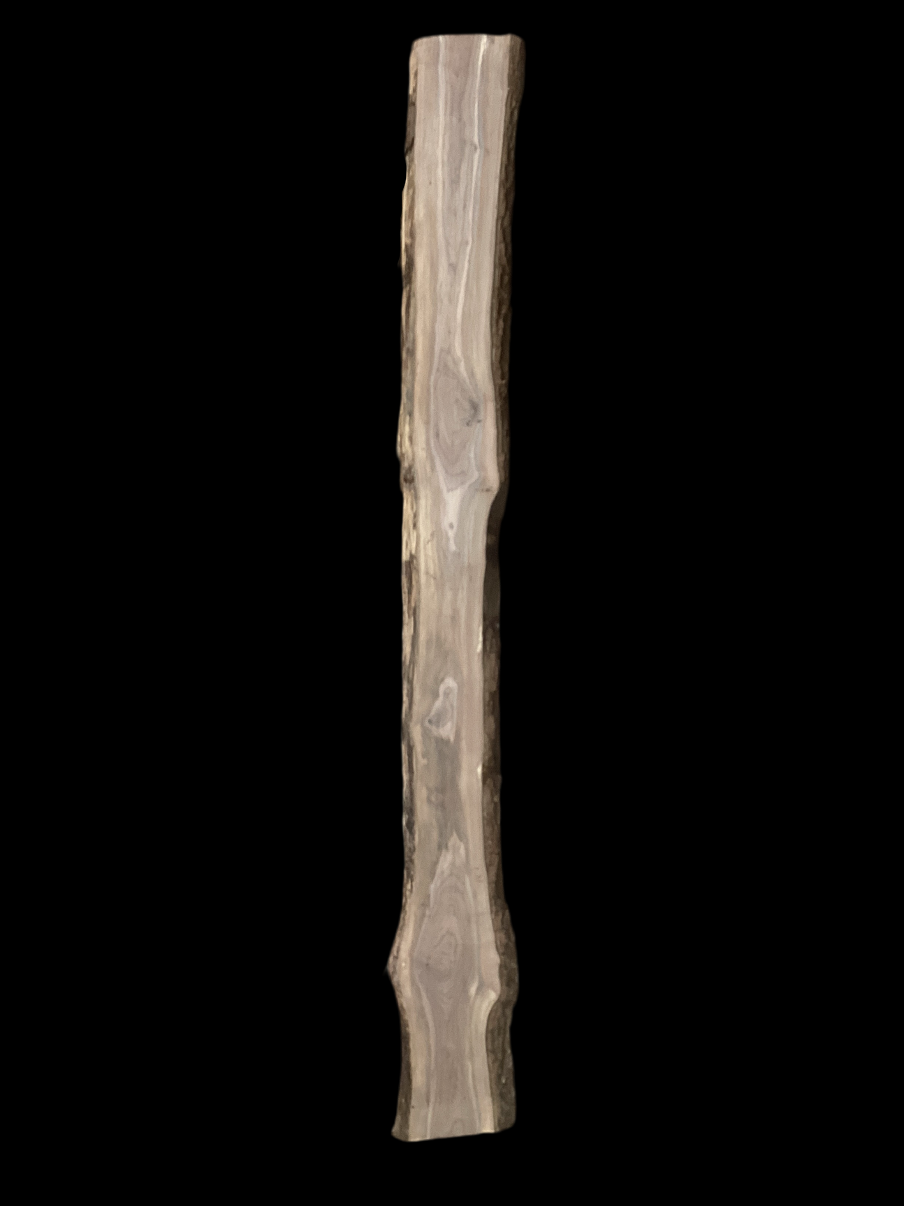 A long slender walnut slab with a black background.