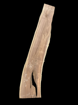 A long walnut slab with a black background. 