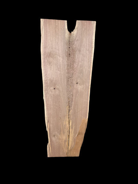 A long walnut slab, wider on one end than the other and on a black background. 