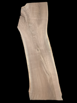 A long walnut slab on a black background. 