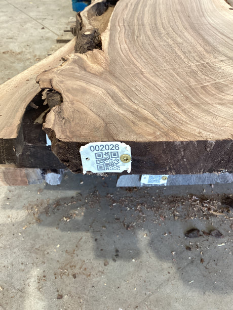 QR label attached to the edge of a walnut slab.