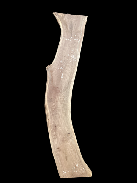 An irregularly shaped walnut slab with a black background.