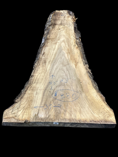 A beige-colored, solid-wood red oak slab with marked dimensions on it, indicating its size and shape.