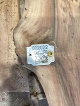 QR label attached to the edge of a walnut wood slab.