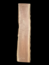 A long walnut wood slab on a black background.