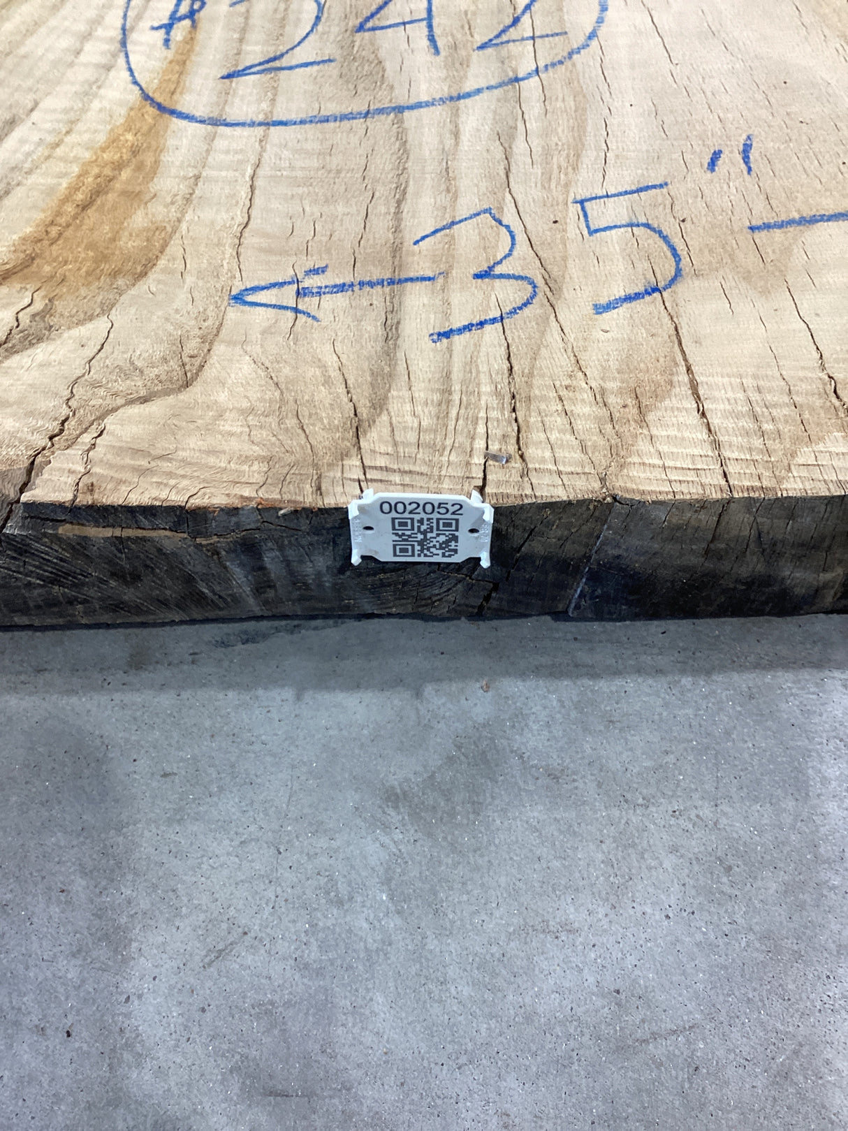QR label attached to the edge of a red wood slab.