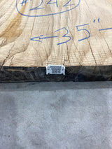 QR label attached to the edge of a red wood slab.